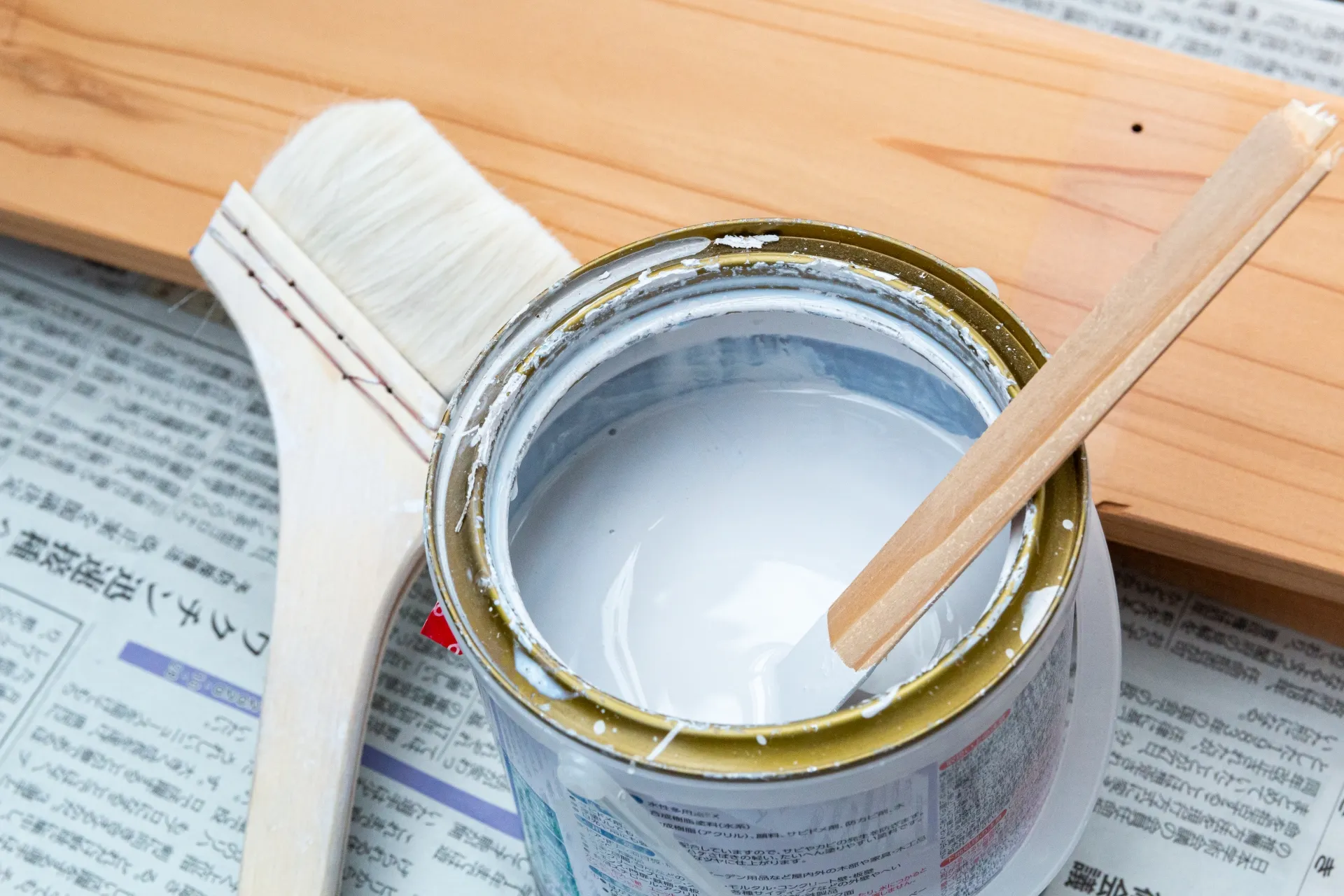 缶に入った塗料とハケを撮影した画像