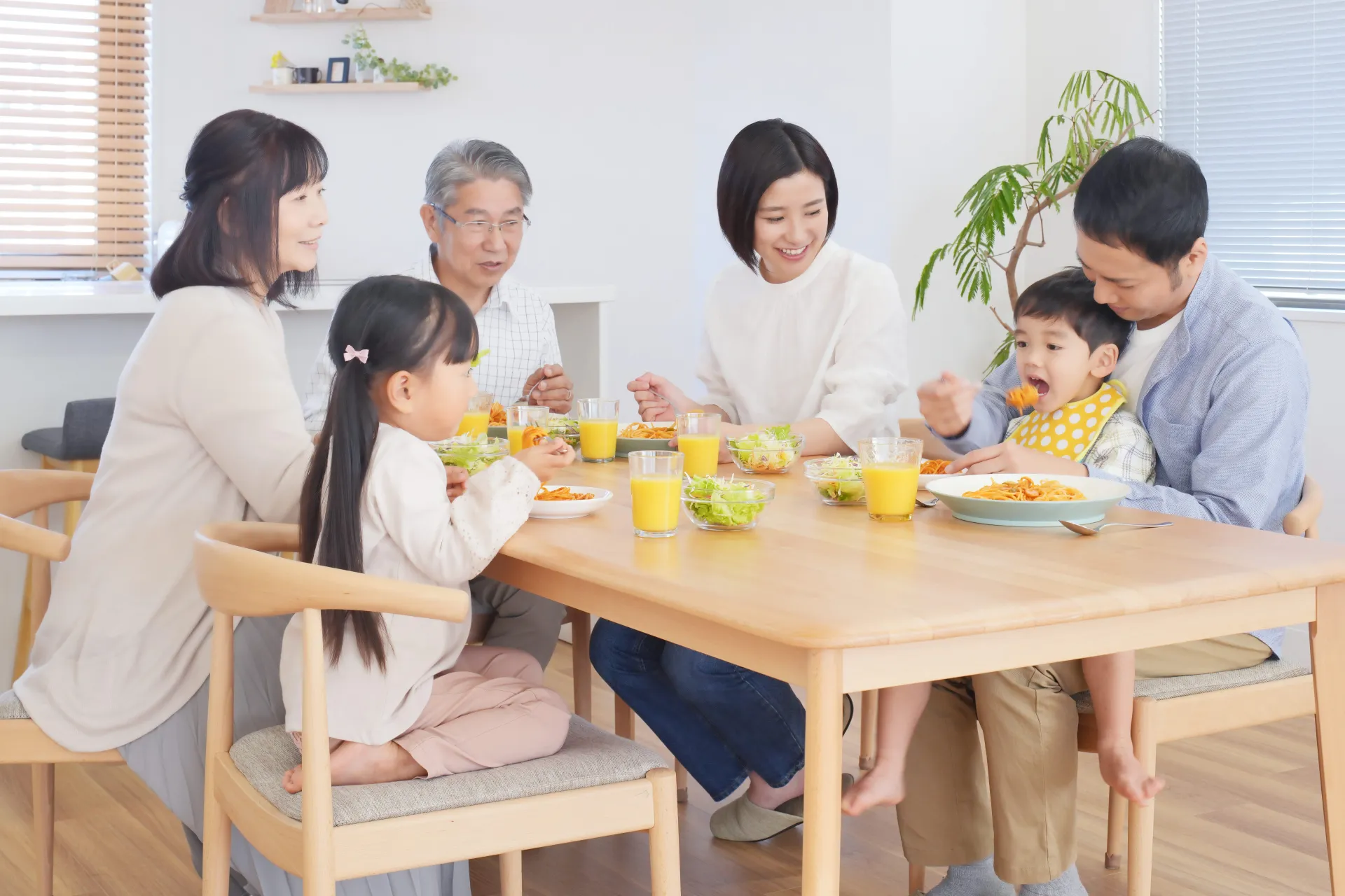 三世代でテーブルを囲んで食事する様子