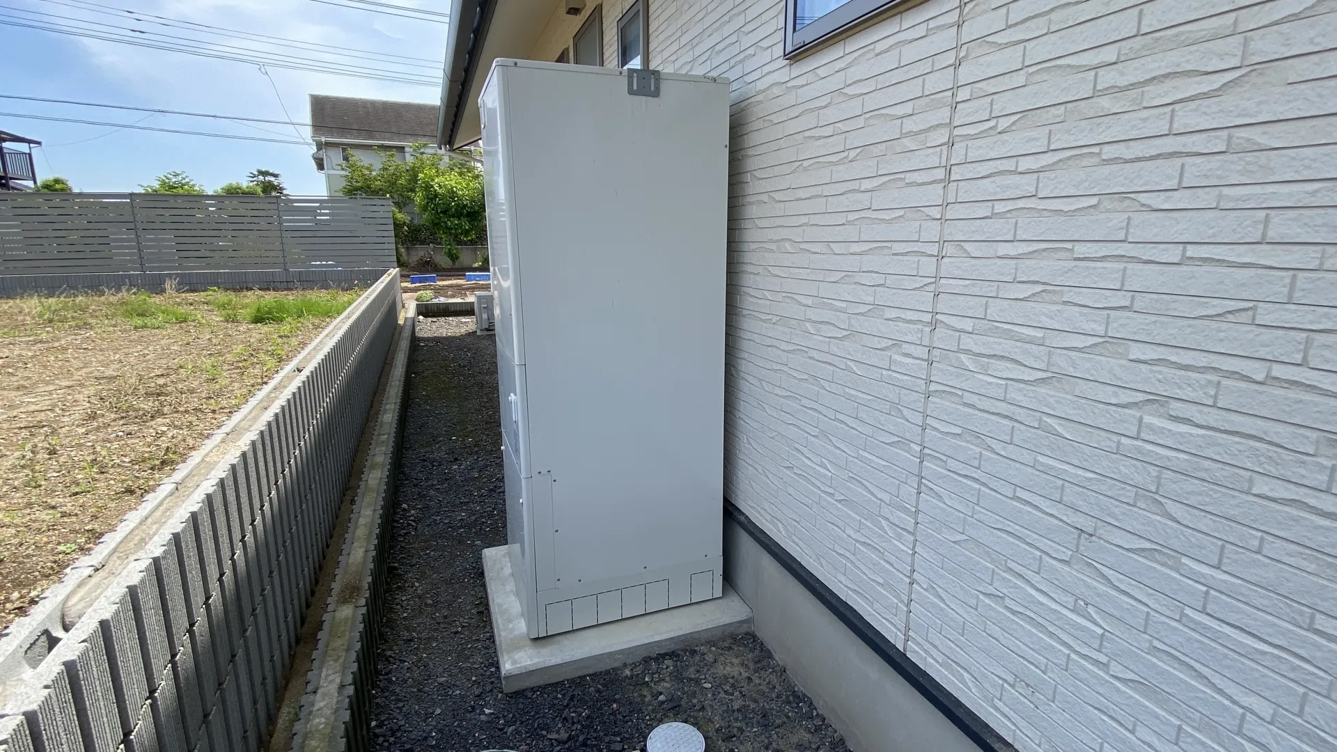 家の外壁に沿って設置されたエコキュートの画像
