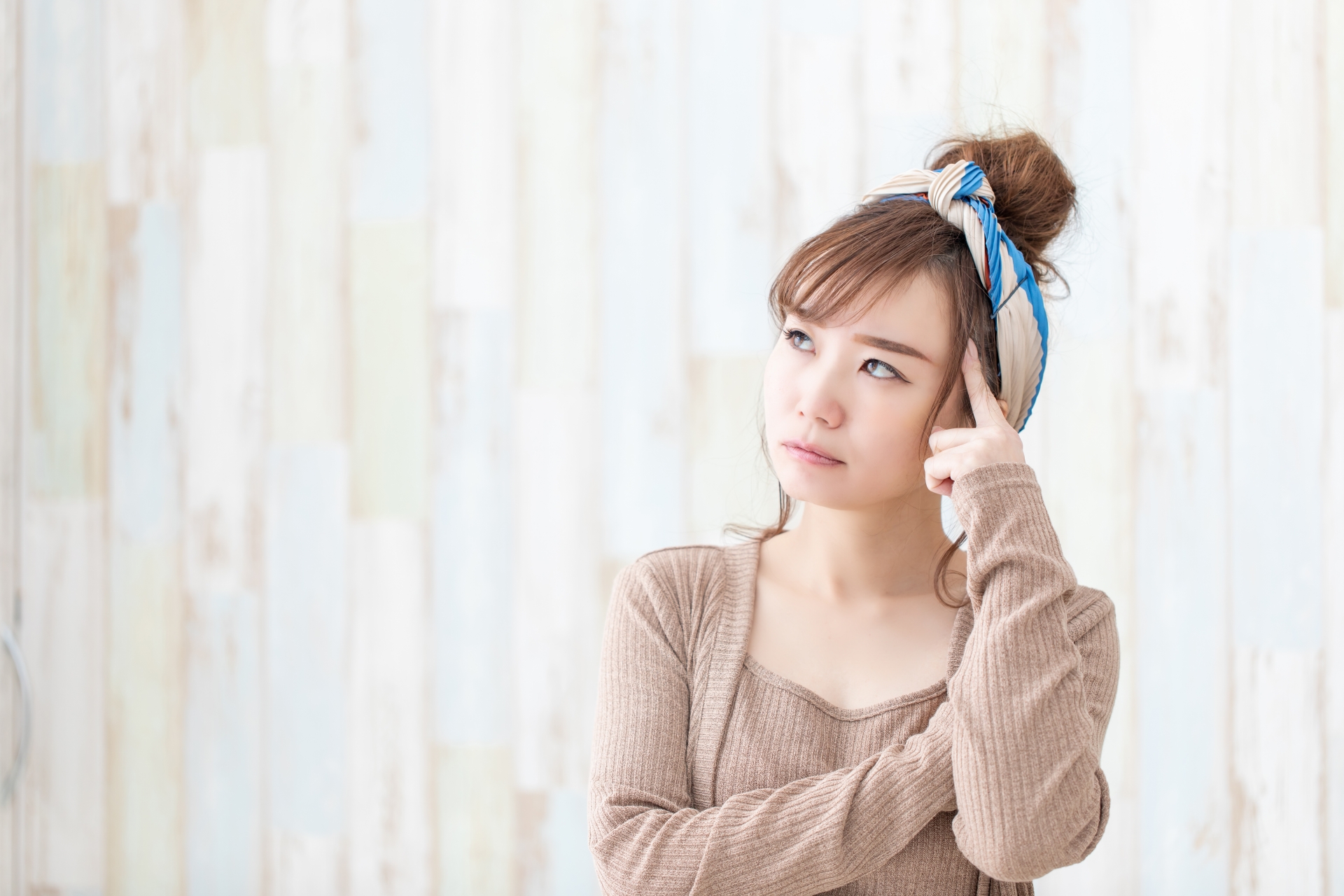 女性が手を頭にあてて悩んでいる様子