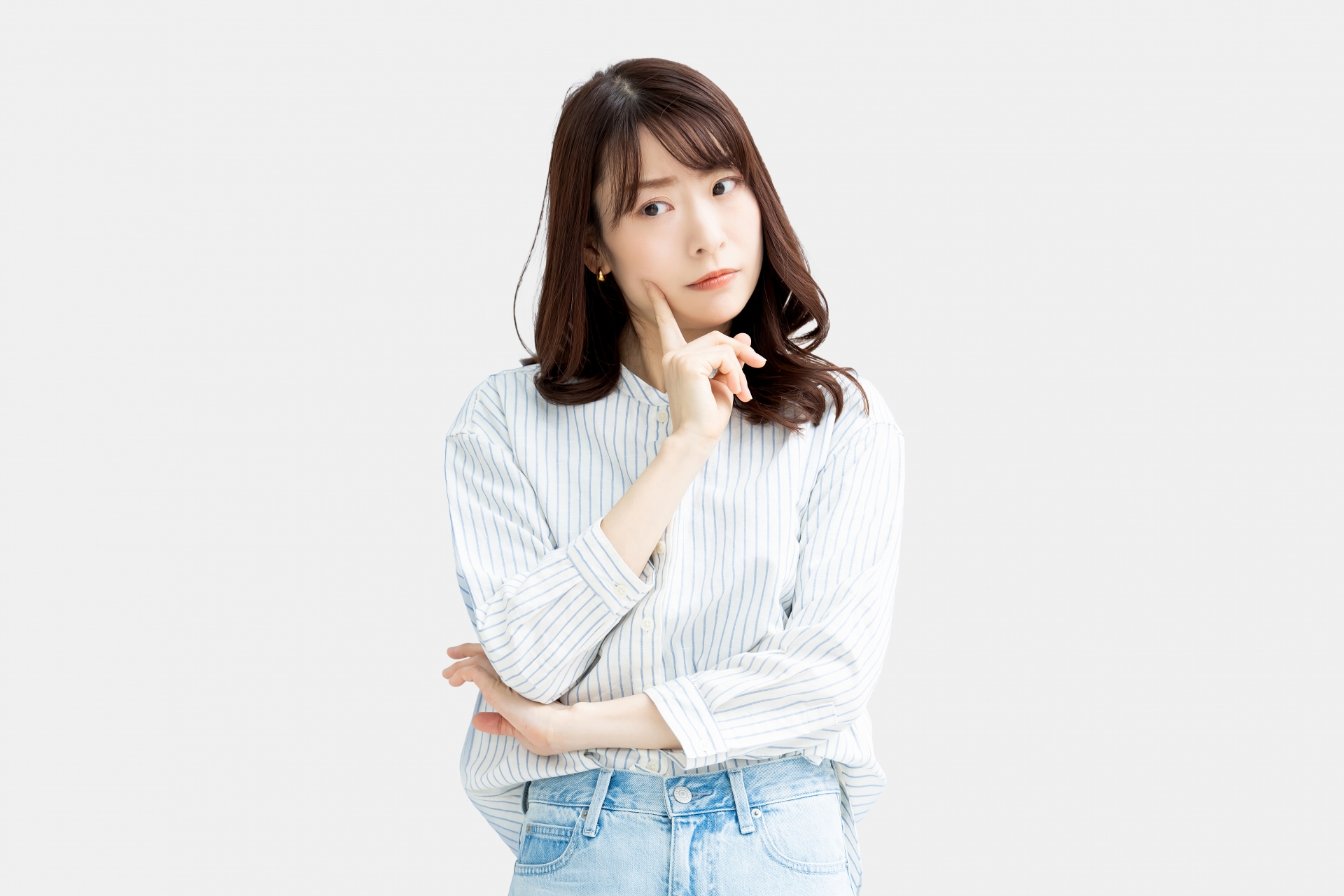 腕を組んで悩んでいる女性の画像